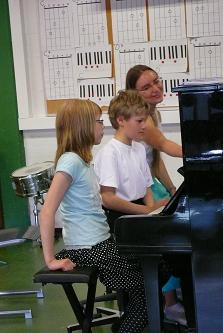 Opettaja ja oppilaat pianon alkeiskurssilla